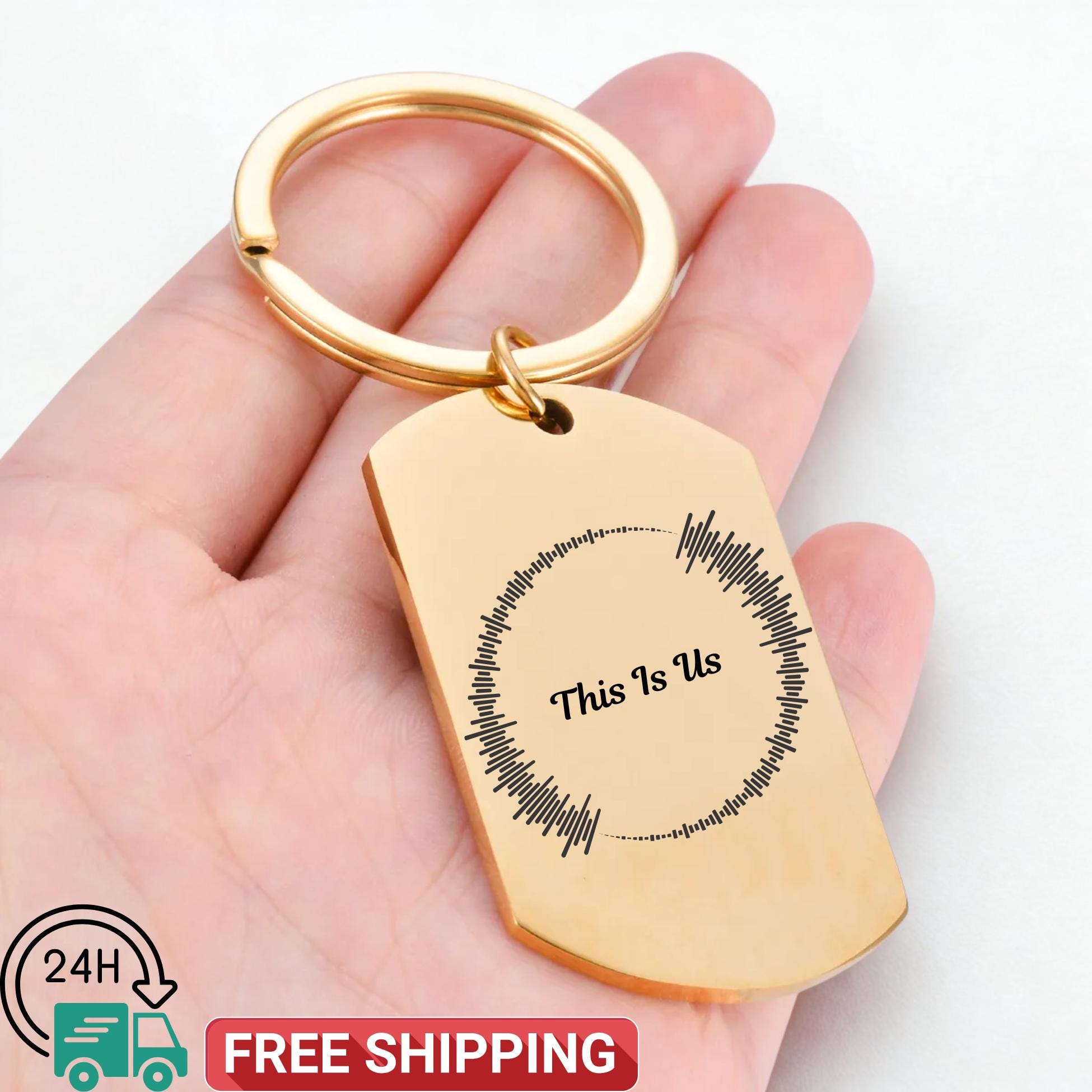 Gold keychain with 'This Is Us' engraving held in a hand, free shipping icon visible.